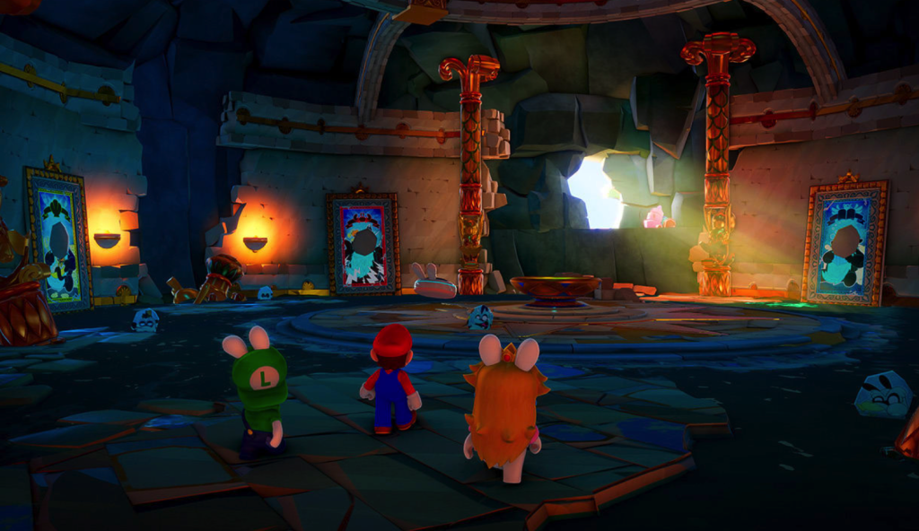 A cartoony 3D image from Mario + Rabbids: Sparks of Hope. Mario, Rabbid Luigi, and Rabbid Peach stand with their backs to the camera inside an abandoned building. The building looks like a ruined palace, with a cracked stone floor, golden ornamentation on the walls, and a hole in the wall that lets out a shaft of light. Torch sconces and paintings line the walls, and two golden pillars stand on each side of the hole in the wall.